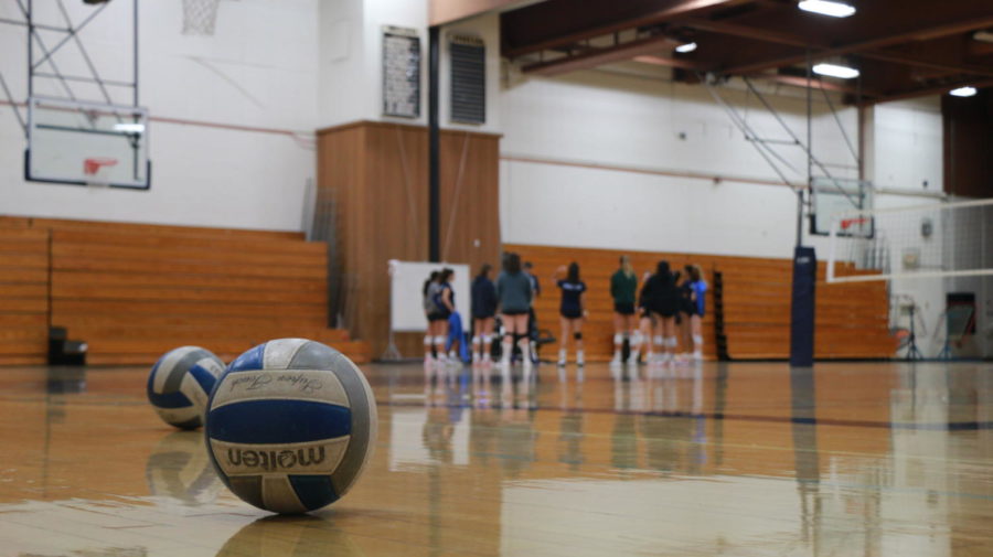The womens volleyball team huddles around Coach Johnson before practice formally starts in the MiraCosta College gymnasium. 